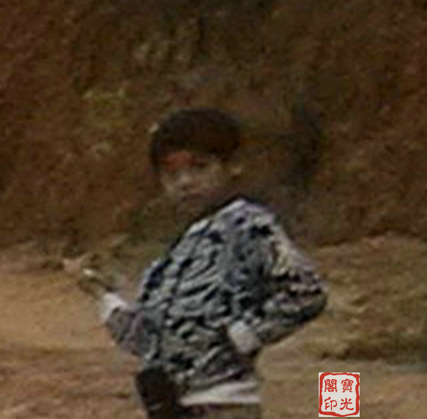 小男孩与他背后的岭壁看起来已融成了一体。